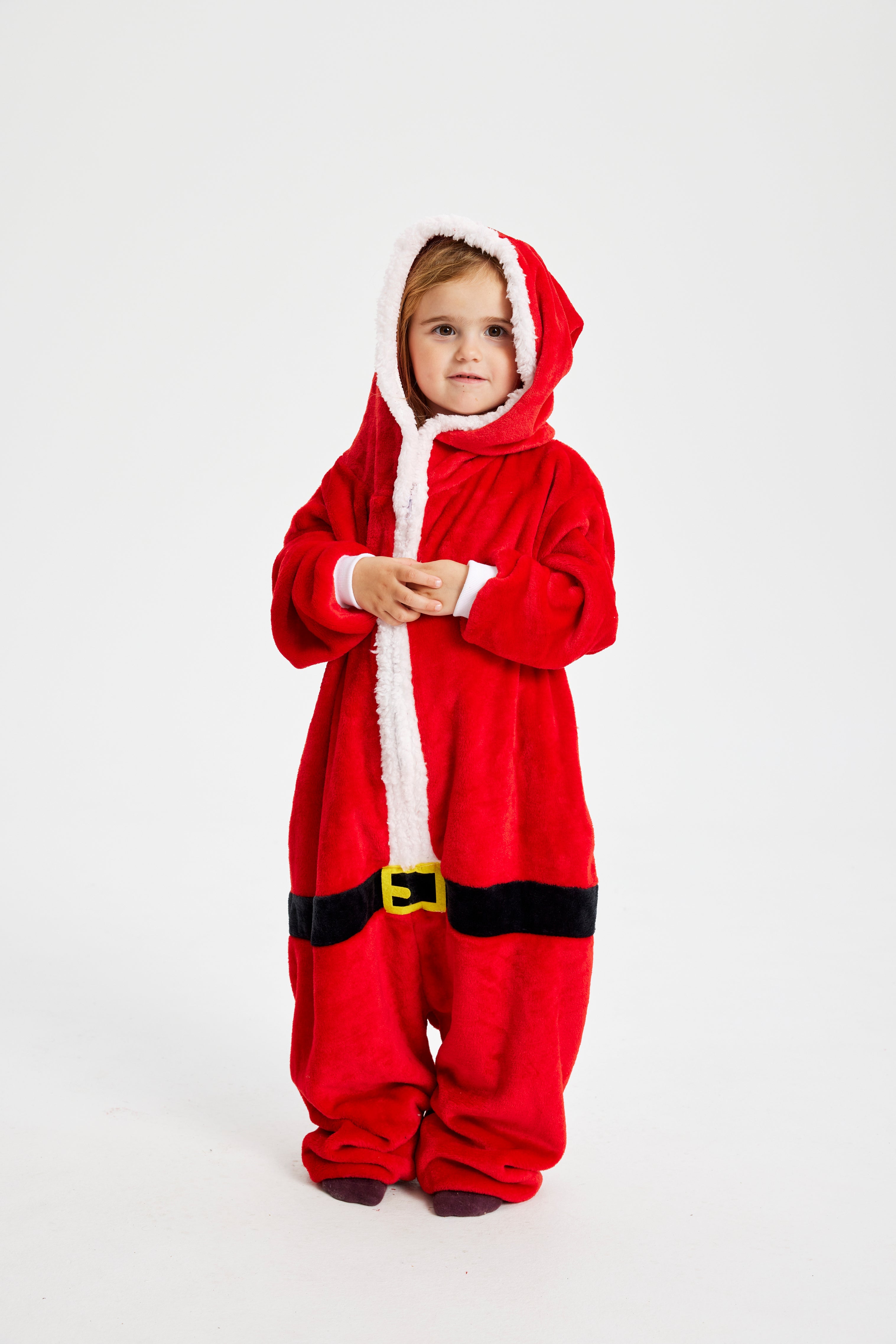 Et barn med en jumpsuit inspireret af julemanden.